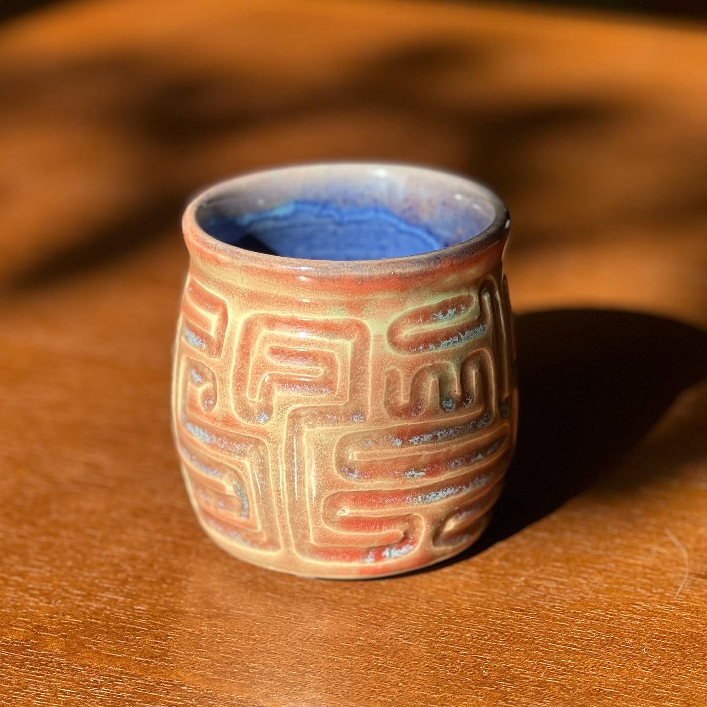 carved red and blue mug